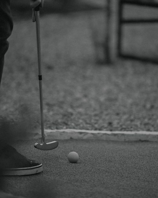 Close-up of a putter and golf ball on the green