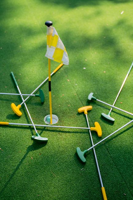 Sunny mini golf course with green turf and sea in the background